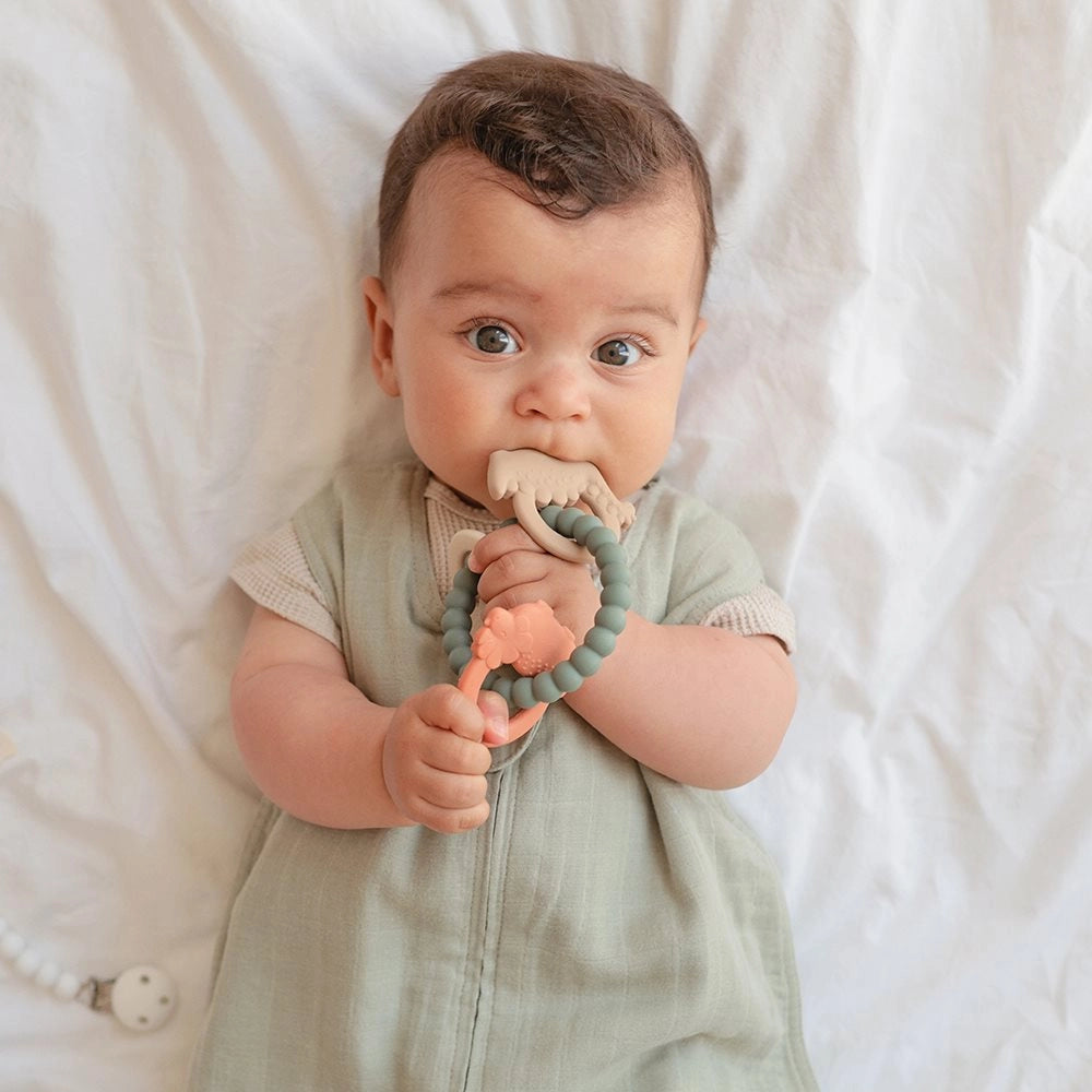 Baby holder og bider i Mushie bidering Dino – blød bidering i silikone til ømme gummer