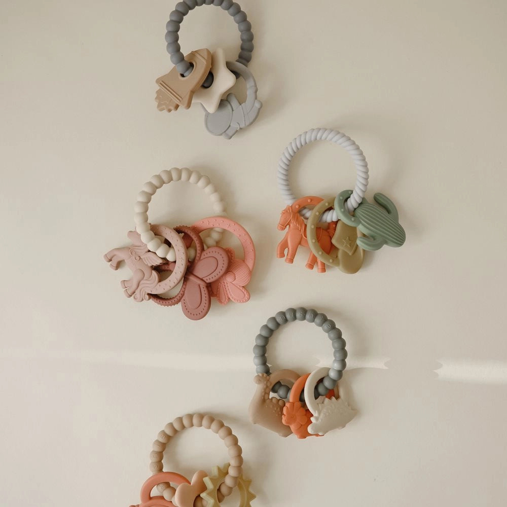 Mushie bideringe i forskellige designs (Western, Dino, Space, Fairy, Nature) – silikone bidering til baby i moderne farver